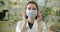 Pharmacist woman puts on a mask at the pharmacy. Professional work during a pandemic