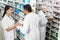 Pharmacists Working By Shelves In Pharmacy