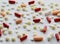 Pharmacology assorted medicine pills, tablets and capsules background pattern texture. Different colors tablet on white