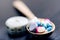 Pharmacy background on a black table with measuring tape. Tablets on a wooden spoon. Pills. Medicine and healthy. Close up of caps