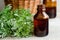 Pharmacy bottle with essential wormwood oil extract, tincture, infusion. Old wooden background. Aromatherapy, spa and herbal