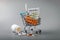 Pharmacy business - shopping cart of pills on gray background