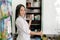 Pharmacy and medicine. Brunette woman with long hair in a lab coat with a smile, takes out the drugs from the locker. Close up