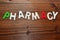 Pharmacy, word with wooden letters on wood background