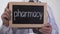 Pharmacy written on blackboard in doctor hands, pharmaceutical industry, drugs