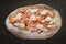 Philadelphia pizza with salmon, shrimps, tomatoes, mozzarella, capers, Philadelphia cheese. Neapolitan round pizza on wood