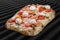 Philadelphia pizza with salmon, shrimps, tomatoes, mozzarella, capers, Philadelphia cheese. Roman pizza rectangular on wood