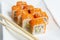 Philadelphia rolls on a white plate with chopsticks. with salmon