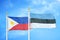 Philippines and Estonia two flags on flagpoles and blue cloudy sky