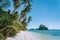 Philippines, Palawan, El Nido beach at low tide, palm tree and amazing Pinagbuyutan island in background. Exotic