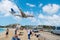 Philipsburg, Sint Maarten - February 13, 2016: airplane land over people on maho beach. Plane low fly on cloudy blue sky. Jet flig