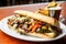 philly cheesesteak with a side of grilled mixed vegetables on a white plate