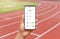 Phone app on running track in woman hand concept