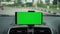 Phone as navigation device, blank green screen smartphone mock up template on car dashboard