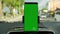 Phone as navigation device, blank green screen smartphone mock up template on car dashboard