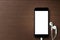 Phone blank screen and headphone on wood table