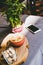 The phone, cappuccino, brown sugar and a vase with bamboo stand on the table.