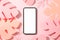 Phone with empty screen and decorative palm leaves on pink background