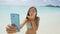 Phone girl using smartphone on beach blowing kiss having fun