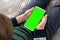 Phone a for keying is holding kid. Smartphone with a green screen in hand child close up top view