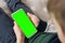 Phone a for keying is holding kid. Smartphone with a green screen in hand child top view