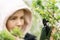 Phone lenses for macro photography. A woman holds a mobile phone with a macro attachment in her hands and takes pictures of plants