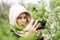 Phone lenses for macro photography. A woman holds a mobile phone with a macro attachment in her hands and takes pictures of plants