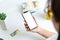 Phone mockup in woman hand. Work desk in background with credit card, plant, books, and coffee mug