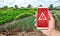 A phone warns of the danger on background of a farm plantation field. Monitoring and analysis of the presence of chemicals