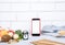 Phone with white mockup  little clock  and different kitchen and cooking utensils on light table. Culinary blog  recipe template