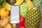 phone with white screen copy space in grocery shopping cart with fruits and vegetables