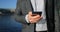 Phone - young businessman using smartphone in smart casual suit by office