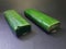 photo of 2 pieces of tempeh wrapped in green banana leaf with black background