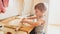 Photo of 3 years old toddler boy rolling dough on wooden board and baking cookies for breakfast. Child cooking on