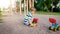 Photo of adorable 3 years old toddler boy playing with sand and you truck and trailer in park. Child digging and