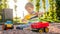 Photo of adorable 3 years old toddler boy playing with sand and you truck and trailer in park. Child digging and