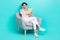 Photo of adorable clever lady trendy clothes sit cozy chair arm hold planner touch eyeglasses empty space isolated on