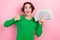 Photo of adorable cool girl dressed green sweater showing thumb up holding cash fan isolated pink color background