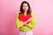 Photo of adorable curly woman dressed green pullover hugging big red paper heart closed eyes isolated pink color