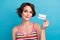 Photo of adorable cute woman dressed striped tank top rising bank card isolated blue color background