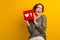 Photo of adorable excited girl hand hold red poster instagram facebook like empty space isolated on yellow color