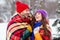 Photo of adorable funny girlfriend boyfriend dressed vests covering plaid duvet laughing embracing walking snow outdoors