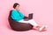 Photo of adorable lady wear trendy outfit sitting pouf watching film speed wifi connection empty space isolated on pink