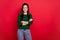 Photo of adorable responsible woman happy smile folded arms dressed stylish green pullover jeans isolated on bright red