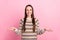 Photo of adorable shiny young woman wear dotted sweater smiling comparing arms empty space isolated pink color