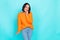 Photo of adorable sweet pleasant girl with straight hairdo dressed orange pullover finger on teeth isolated on teal