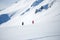 Photo from afar of two sporty skiers in snowy resort