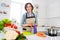 Photo of age brunette lady cut carrot wear apron jeans shirt at kitchen alone