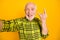 Photo of aged man happy positive smile show rock sign tongue-out make selfie isolated over yellow color background