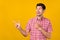 Photo of amazed curious young happy man point fingers empty space sale look isolated on yellow color background